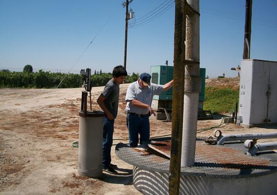 Jerry Mendoza, student reporter (left); and Dave McIntyre, District Manager for Caruthers CSD inspecting the lift station at the wastewater treatment plant.