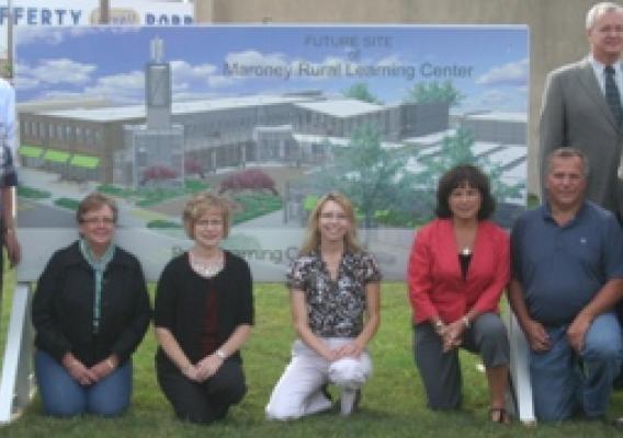 USDA and local officials in front of a rendering of the newly designed learning facility.