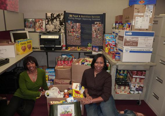 Angela Jones and Michelle Stewart with part of the donations collected by the Midwest Regional Office for the Feds, Farmers, and Friends Feed Families food drive.