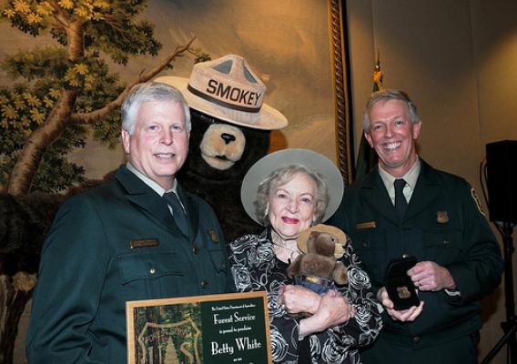 Actress Betty White holds the certificate and Forest Ranger badge presented to her by US Forest Service Chief Tom Tidwell (left) and Deputy Chief Hank Kashdan, as Smokey Bear looks on. White was named an Honorary Forest Ranger in a ceremony at the Kennedy Center for the performing Arts in Washington DC November 9. (US Forest Service photo by Karl Perry) 