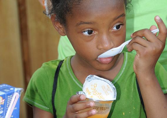 A little girl enjoys her applesauce which was part of her Summer Food Service Program meal at Light of the Village in Prichard, Ala., July 8.   