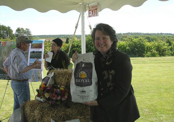Deputy Agriculture Secretary Kathleen Merrigan holds a sack of Rhode Island potatoes produced at Ferolbink Farm