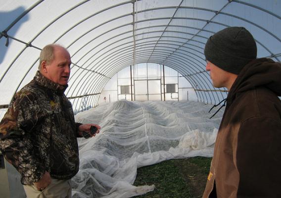 Farm owner Andy Dunham (wearing cap) explains his crop production system to John Whitaker, FSA Iowa State Executive Director