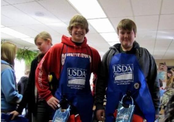 Huntsville Middle School 8th Graders, Colby Smith and Cody Levan, display the food safety gear given to them by FSIS employees.
