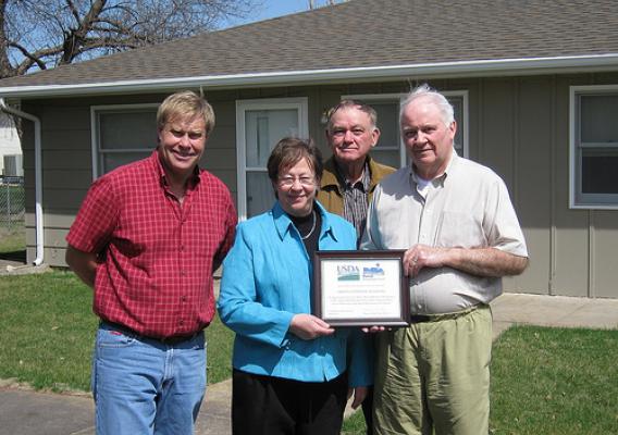 USDA Rural Development Nebraska State Director Maxine Moul presented a plaque for the more than 40 years of service by Gibbon‘s Centennial Manor to board members, left to right, Bob Godberson, Duane Frazier and Duncan McGregor.  Board members not present for the April 2 event were Bob Clevenger and Fred Reed.