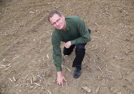 Illinois field office director Brad Schwab examines a field of early planted corn in central Illinois. (NASS)