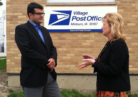 Pictured in Minburn, Iowa, are John Padalino and Deb Lucht, general manager, Minburn Communications.  USDA recently helped finance a telecommunications upgrade in Minburn.  Minburn Communications also announced last month that it would be Iowa’s third Village Post Office, a partnership program with the U.S. Postal Service to assist communities facing a reduction in hours at their local post office. Minburn’s post office is now open only four hours a day. Customers with basic postal needs can visit Minburn C