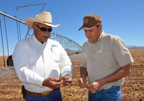 Newly installed pivot irrigation lines run behind Gerry Gonzalez, NRCS district conservationist in Douglas (left) and farmer Alfredo Zamora.