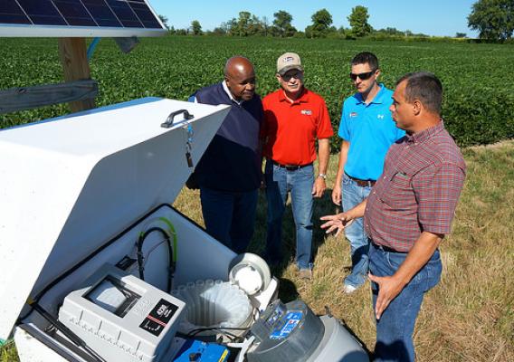 U.S. Department of Agriculture (USDA) Agricultural Research Service (ARS) engineer Kevin King (right) explains an edge of field water quality monitoring station to Ohio State Conservationist Terry Cosby, farm owners Joe and Clint Nester in the Western Lake Erie Basin near Bryan, Ohio on Thursday, Aug. 14, 2014. The device allows tracking of both surface and underground water moving thru field tile. Monitoring stations results help determine what may be best farming practices on different types of soil in th