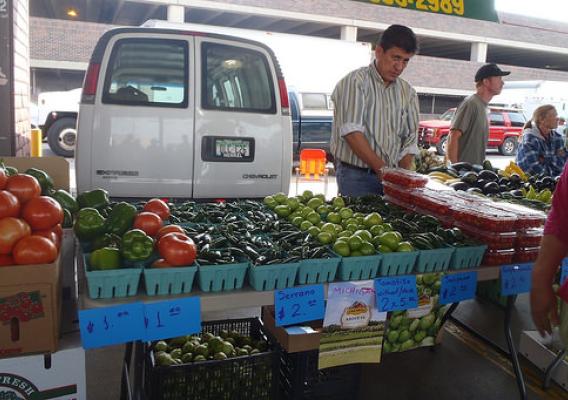 Board President Filiberto Villa Gomez, setting out produce at a farmers market, has been the driving force behind Farmers on the Move cooperative.