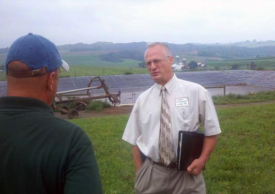 Lambert Rosenbaum, USDA Rural Development Area Director (right) discusses the newly installed anaerobic methane digester at Pennwood Farms in Somerset County, Pa. with Merv Yoder of RCM Digesters, the installer. The digester is currently producing more than enough energy to operate the farm.
