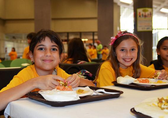 Three children enjoy lunch freshly prepared and served on-site by a food service management company at the Inter Metro Summer Recreation Program in San Juan, Puerto Rico.