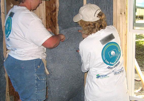 Volunteers prepare to install eco-friendly insulation in a Habitat for Humanity home. 