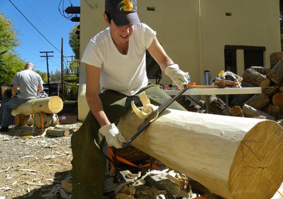 An HistoriCorps volunteer smooths a log to be used in the restoration of the Saguache Ranger Station on the Rio Grande National Forest. The restoration effort helped the U.S. Forest Service earn a 2011 National Preservation Honor Award from the National Trust for Historic Preservation.