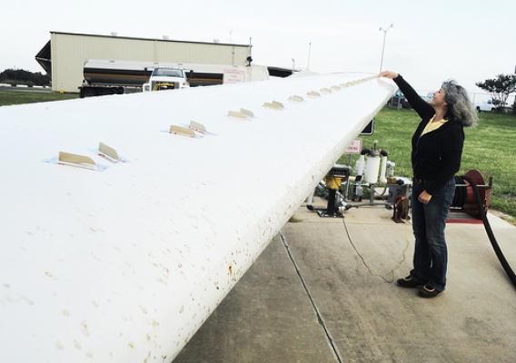 Anni Brogan, owner and president of Micro Aerodynamics, inspecting vortex generators (VGs) on the wings of a small aircraft