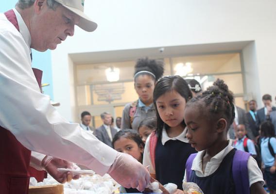 Agriculture Secretary Tom Vilsack serving breakfast to students at Robert E. Lee Elementary