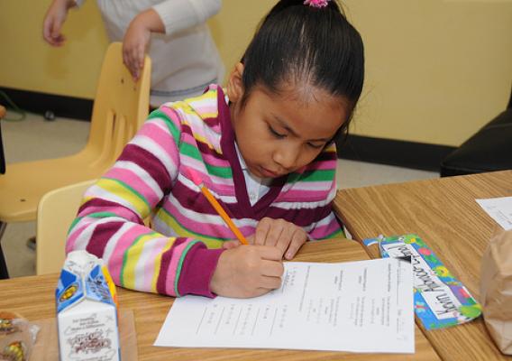 A student works hard on her assignment while eating a grab ‘n’ go breakfast in Mikelle Caine’s second grade advance class at Lake Forest Elementary School, Sandy Springs, Ga., (USDA photo by Debbie Smoot).