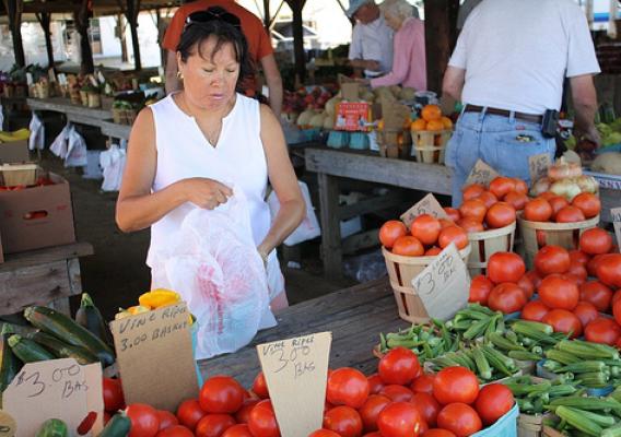 A vendor places tomatoes into a plastic bag for a customer at a Maryland farmers market.  Many beginning producers use farmers markets as the gateway to direct marketing opportunities. Photo by Elvert Barnes