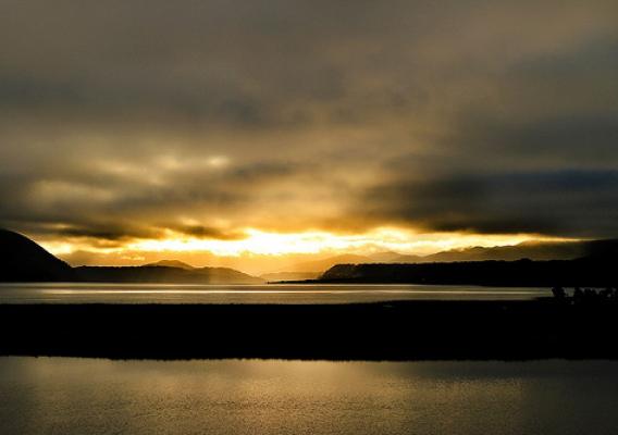 The sunrise over Lago Cucao with Chiloe National Park on the left shoulder of the slopes in background.  Photo courtesy of Michael Olwyler.