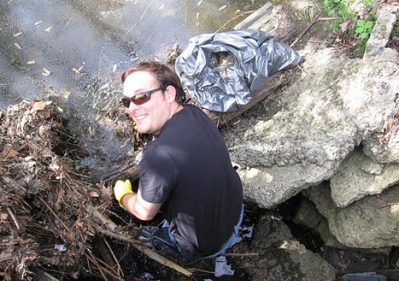 Working as an Earth Team volunteer, Cartographic Technician Jonathan Bowlin pulls trash from a stream near his office in Greensboro, N.C.