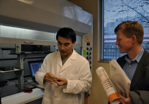 The Food Innovation Center’s Dr. Quingyue Ling shows USDA’s Max Finberg how new technology can laser-imprint tracking data on individual food items as small as a grain of rice at the center’s Radio Frequency Identification Lab. 