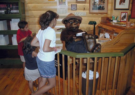 Smokey Bear greets visitors and reads his mail at Forest Service Information Center.