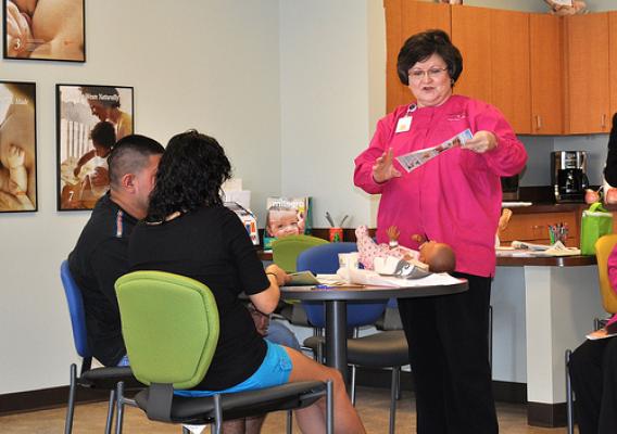 Lactation consultant Mary Jo Williams discusses proper breastfeeding techniques with parents at the Dallas Community Baby Café. 