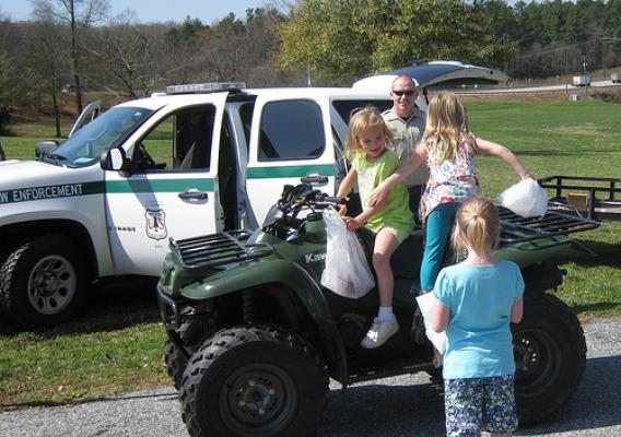 Officer Derik Breedlove gives potential future Forest Service law enforcement officers an opportunity to try out the view from an ATV seat.  Photo credit: USDA Forest Service/Stuart Delugach
