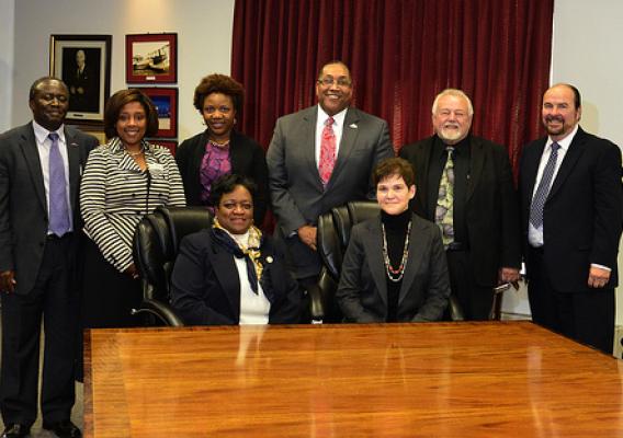USDA Deputy Agriculture Secretary Krysta Harden (seated right) announces USDA funding for the first graduate school dorms at the University of Maryland Eastern Shore. Seated next to her is  University of Maryland Eastern Shore (UMES) President Dr. Juliette B. Bell.  (Standing) left to right, Moses Kairo, dean of UMES’ School of Agriculture and Natural Sciences, UMES executive vice president Kim Dumpson; Danette Howard, the Maryland Secretary of Higher Education; Dale Wesson, UMES’ research and economic deve