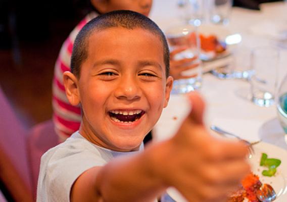 A child at a summer meals site enjoys a tasty and nutritious meal.  