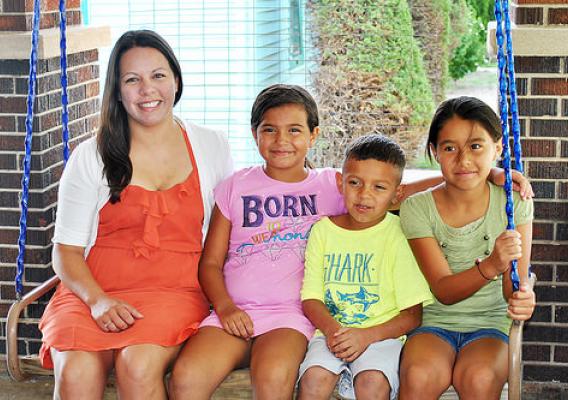 Megan Estrada and her children enjoy a swing on the porch of their new home financed by a USDA Rural Development home loan guarantee.