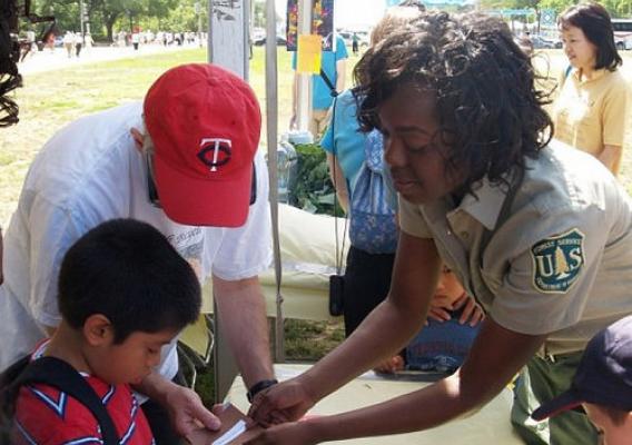Michaela Hall, a workforce program specialist for the U.S. Forest Service, leads an educational activity to explain how important the sun is to plant life during a National Get Outdoors Day Event held in Washington, D.C.  (U.S. Forest Service photo/Victor Fowler)