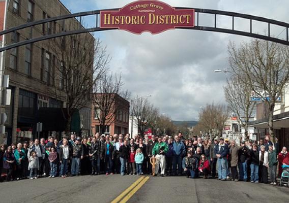 Cottage Grove residents stand under an arch welcoming visitors to the newly restored downtown area.  