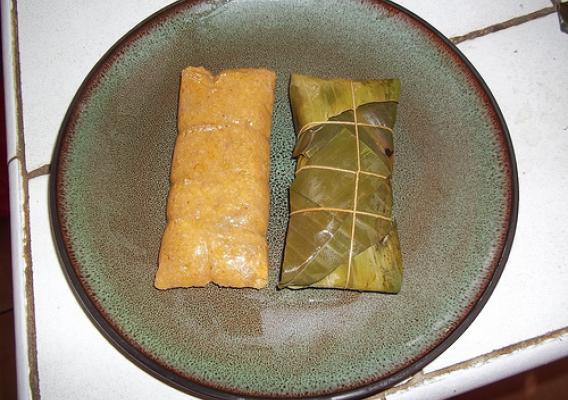 A photo of pasteles, which are made from ground banana stuffed with meat or chicken, wrapped in a banana leaf and cooked.  These were prepared using bananas donated from the research station.