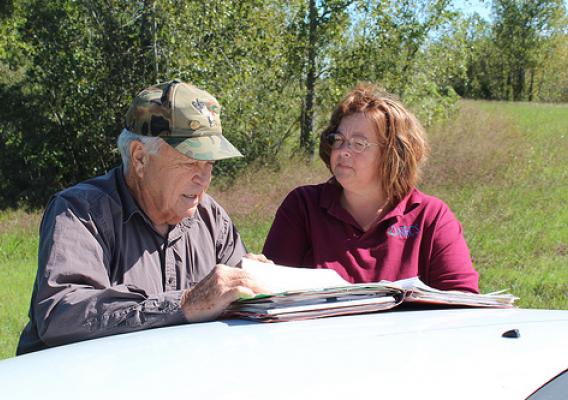 Ron Farris, landowner, and NRCS employee Danette Cross look over his conservation plan.