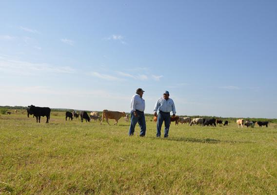 Javier Mancha, right, visits with NRCS District Conservationist Serafin Aguirre about pasture conditions and grazing plans for his cattle.