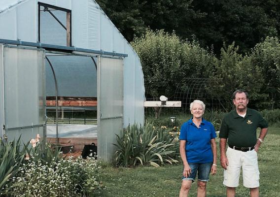 Farmers Scott and Susan Hill in front of their pollinator garden