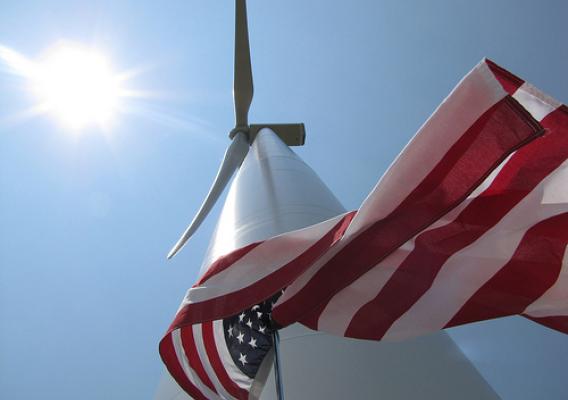 An American flag flying next to a new wind turbine