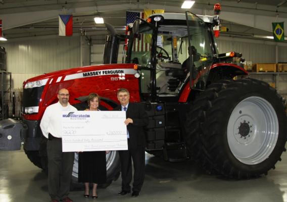 Eric Fisher, AGCO; Colleen Landkamer, USDA Rural Development State Director; and Richard Burud, Federal Rural Electric; in front of a Massey Ferguson tractor built at AGCO’s facility in Jackson, Minn.  Federated provided a loan to AGCO through the efforts of USDA Rural Development. 