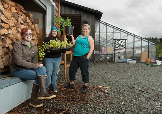 Three high school girls show off a crop