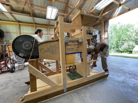 People inspecting a fanning mill